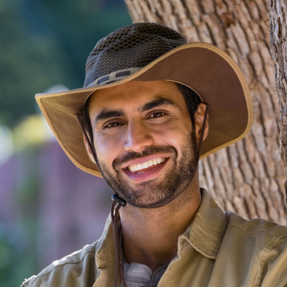 smiling man standing with arms crossed near tree t D8P8B96 1 1 1